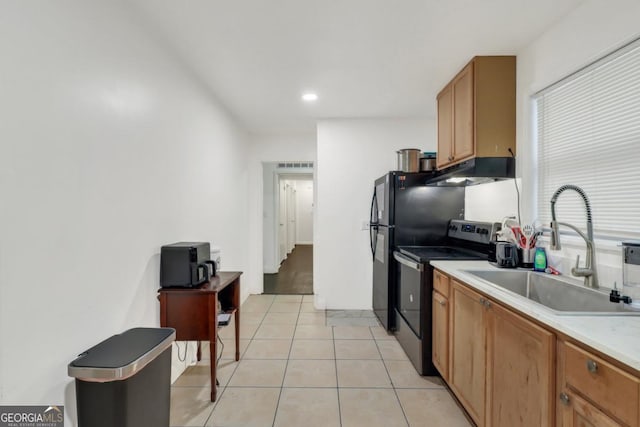 kitchen featuring black fridge, sink, stainless steel range with electric cooktop, and light tile patterned floors