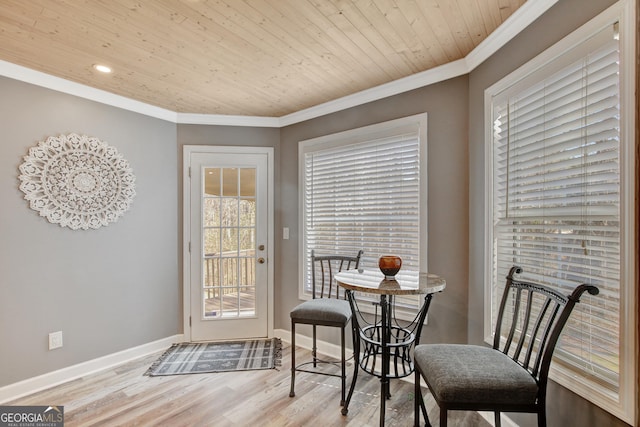 dining room featuring ornamental molding, wood ceiling, and light wood-type flooring