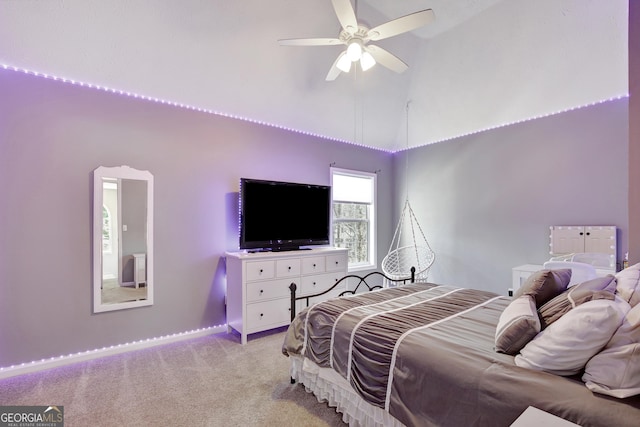 carpeted bedroom with ceiling fan and high vaulted ceiling