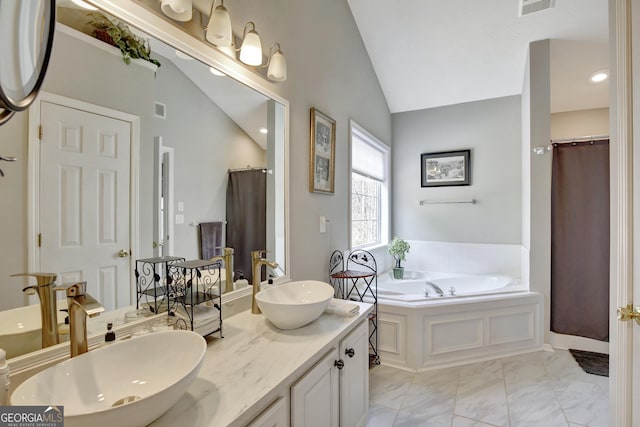 bathroom with a washtub, vanity, and lofted ceiling