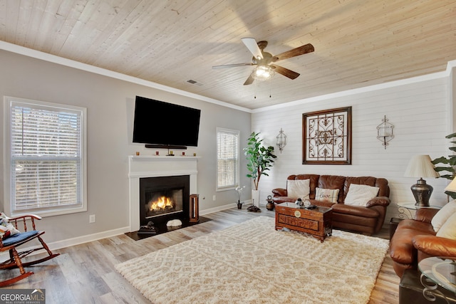 living room with wood ceiling, ornamental molding, light hardwood / wood-style flooring, and a wealth of natural light