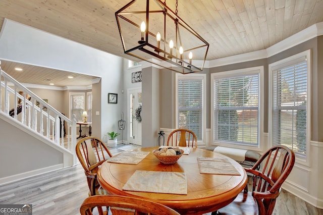 dining area featuring crown molding, wooden ceiling, and light hardwood / wood-style floors