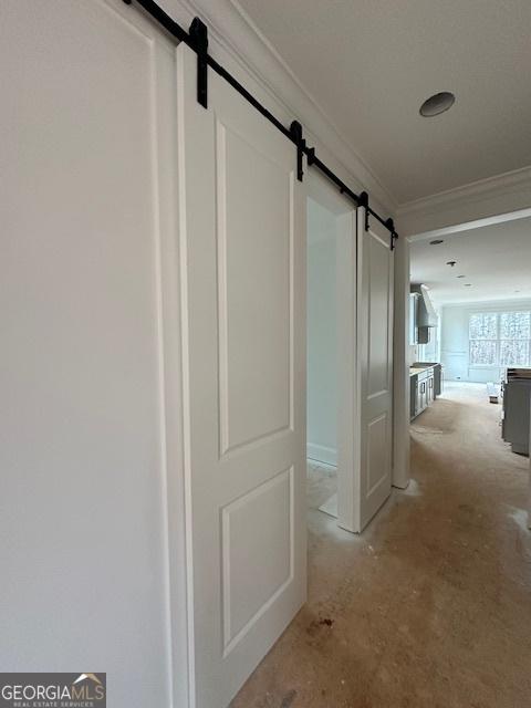 corridor with crown molding and a barn door