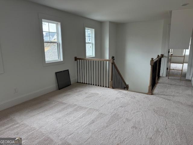 carpeted spare room featuring baseboards