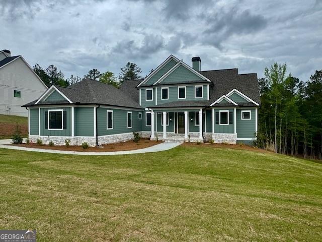 view of front of home with a chimney, a front lawn, and a porch