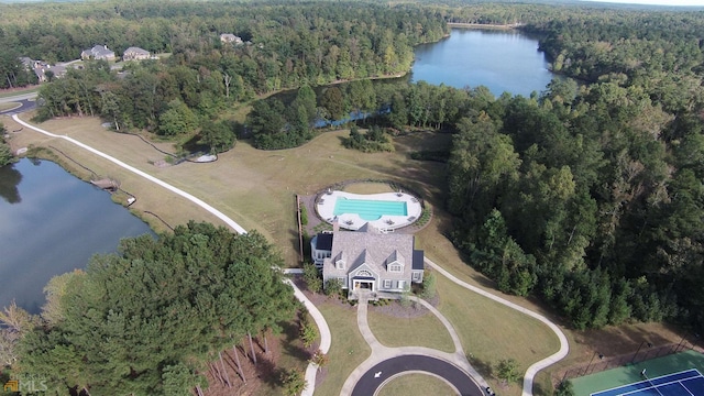drone / aerial view with a wooded view and a water view