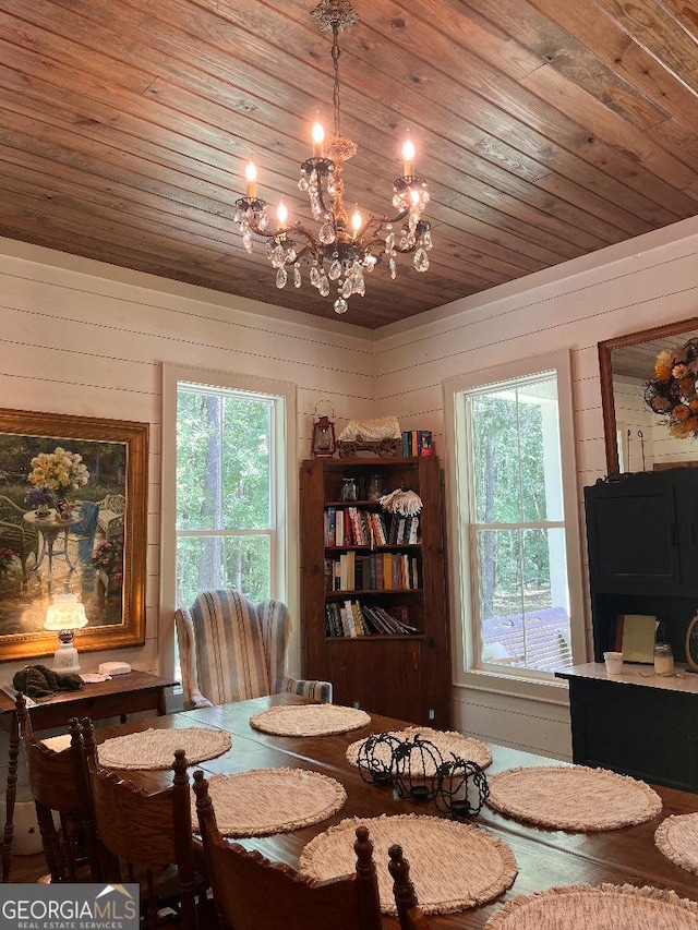 dining area featuring wood ceiling, a healthy amount of sunlight, wooden walls, and an inviting chandelier