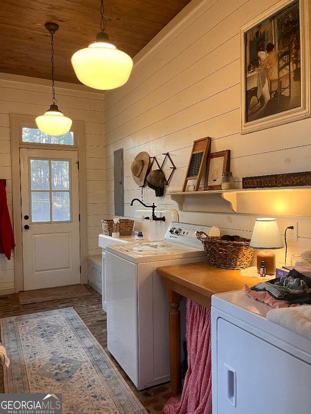 clothes washing area with dark hardwood / wood-style floors, wooden walls, wood ceiling, and washer and clothes dryer