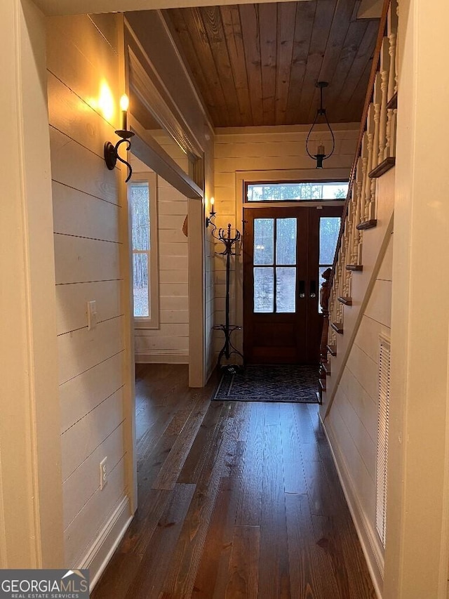 entryway featuring dark hardwood / wood-style flooring, wooden walls, a wealth of natural light, and wood ceiling