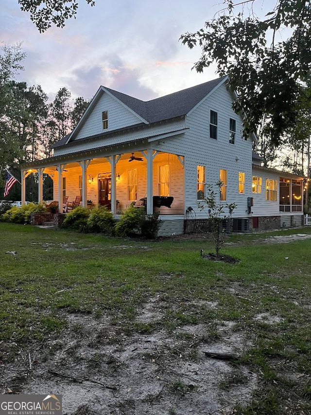 182 Rogers St, Hazlehurst, GA 31539 - back of property with a yard, a porch, a shingled roof, a ceiling fan, and cooling unit