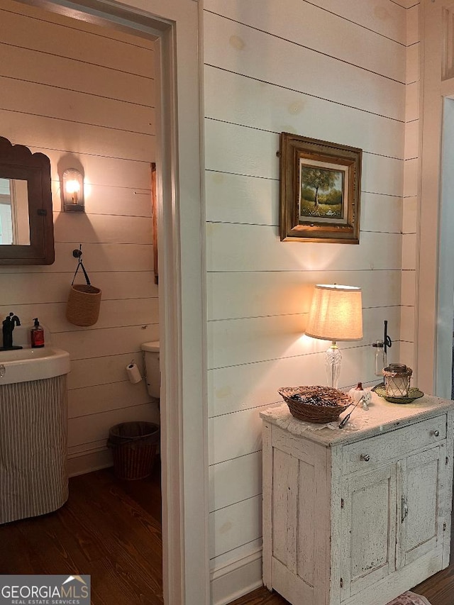 bathroom with hardwood / wood-style flooring and wooden walls