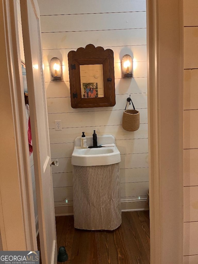 bathroom featuring vanity, hardwood / wood-style flooring, and wooden walls