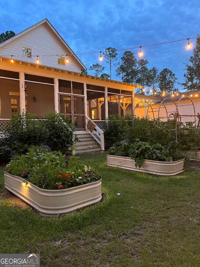 182 Rogers St, Hazlehurst, GA 31539 - rear view of property with a sunroom, a vegetable garden, and a yard