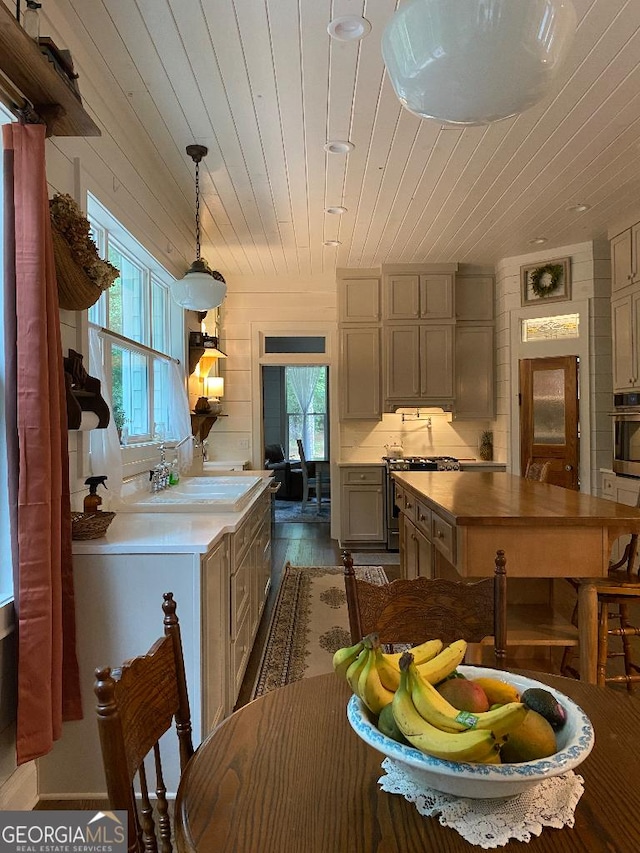 kitchen featuring sink, decorative light fixtures, wooden ceiling, hardwood / wood-style flooring, and stainless steel appliances