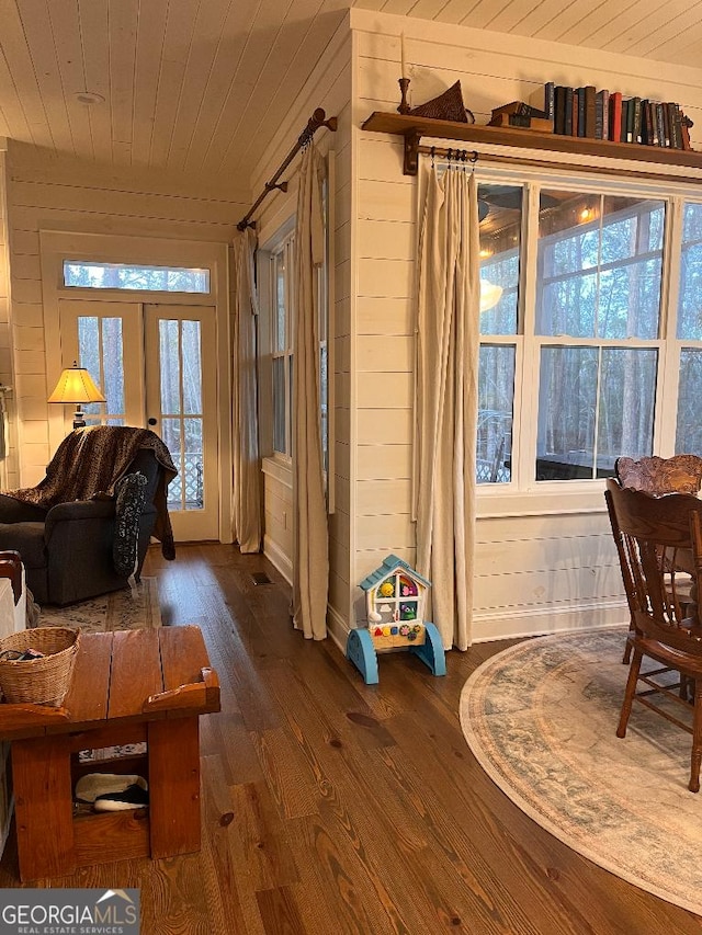 interior space featuring dark wood-type flooring, wood walls, wood ceiling, and french doors