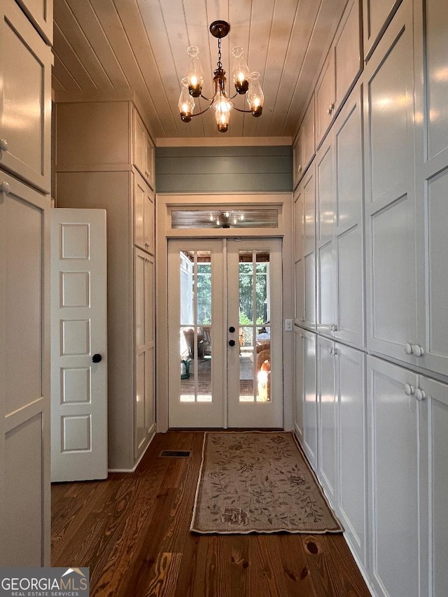 doorway to outside featuring an inviting chandelier, wood ceiling, dark wood-type flooring, and french doors