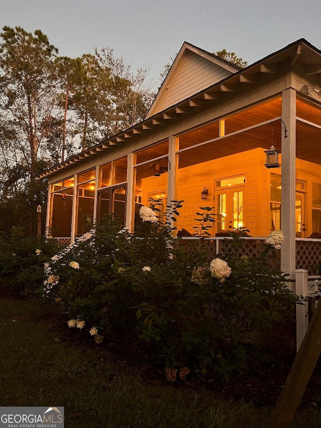 property exterior at dusk featuring a sunroom