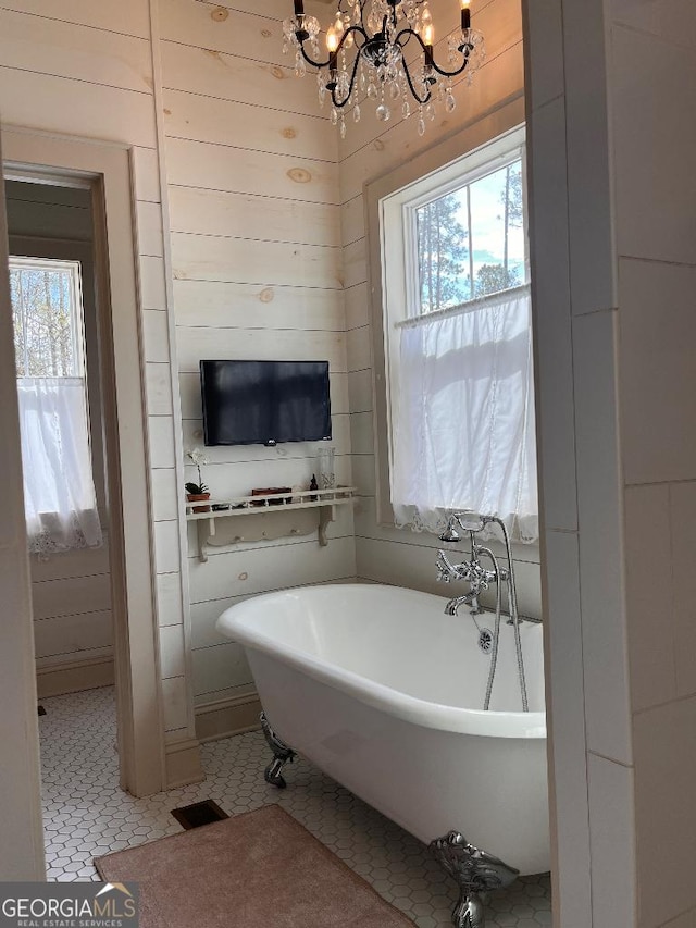 bathroom featuring a tub and a notable chandelier