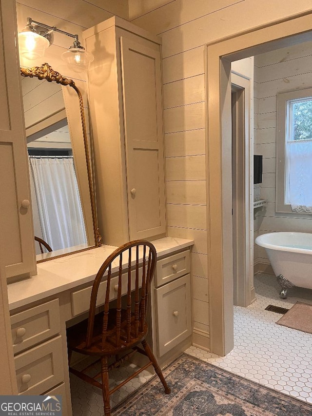 bathroom featuring tile patterned flooring, a bathing tub, and wooden walls