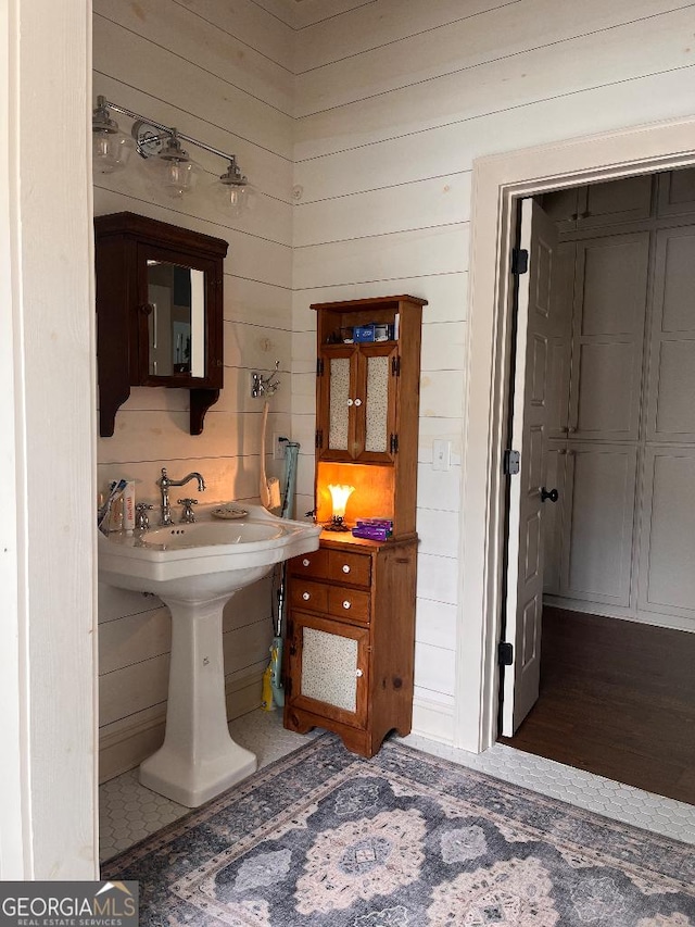 bathroom featuring wooden walls