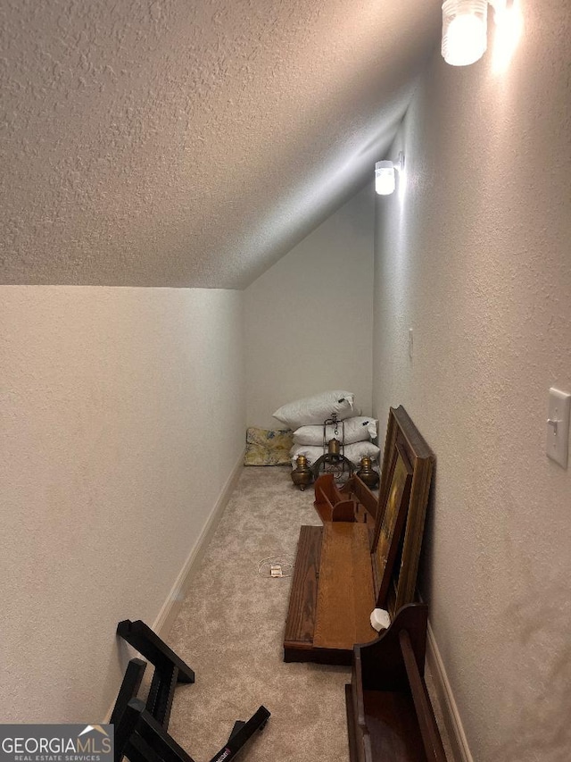 bathroom with lofted ceiling and a textured ceiling