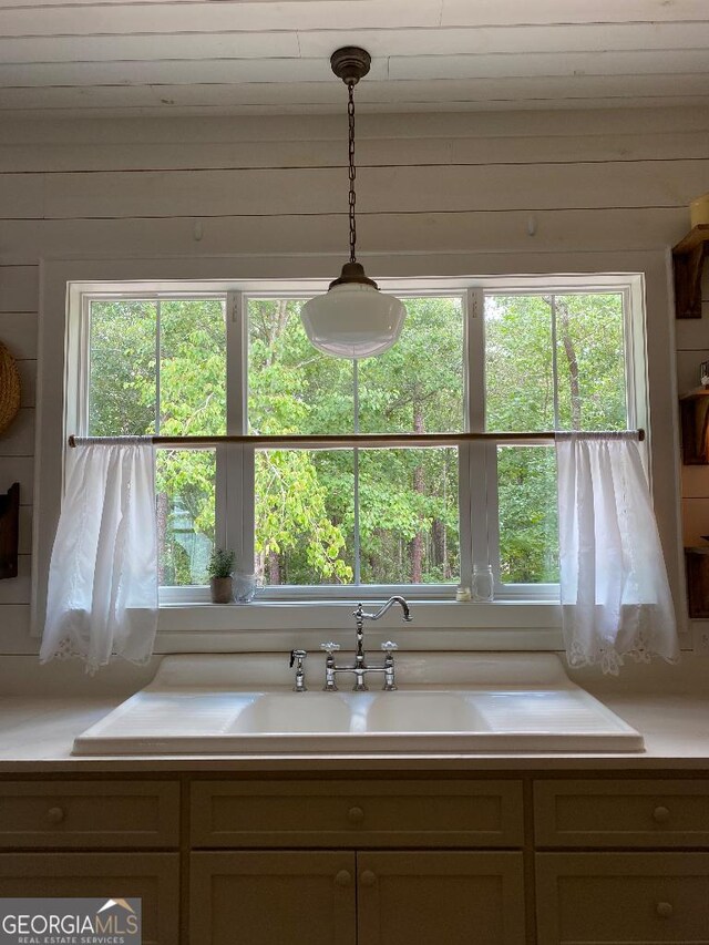 182 Rogers St, Hazlehurst, GA 31539 - kitchen featuring light countertops, hanging light fixtures, wood walls, and a sink