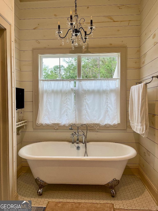 182 Rogers St, Hazlehurst, GA 31539 - bathroom with healthy amount of natural light, wooden walls, tile patterned floors, and a freestanding bath