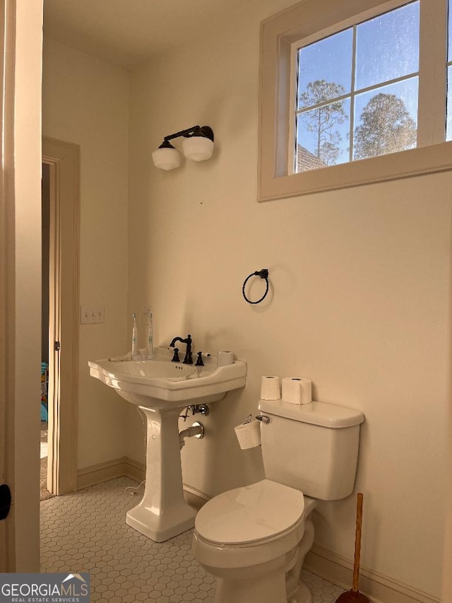 182 Rogers St, Hazlehurst, GA 31539 - bathroom with baseboards, toilet, and tile patterned floors
