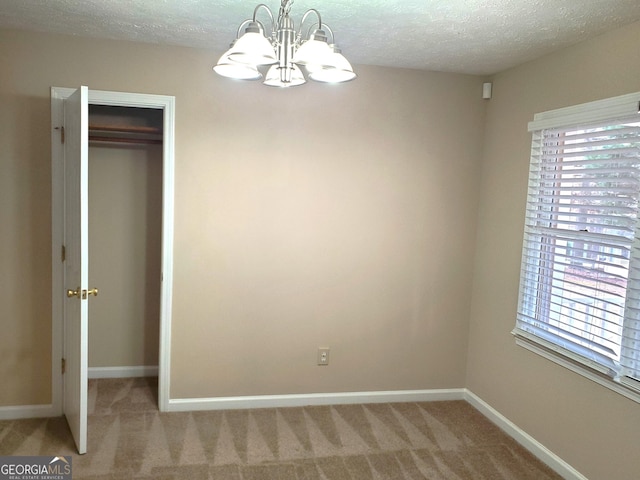 interior space featuring a closet, a chandelier, carpet, and a textured ceiling