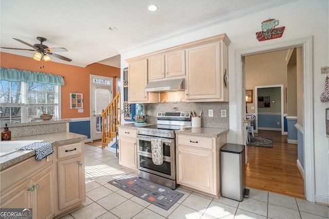 kitchen featuring light brown cabinets, light tile patterned floors, double oven range, ceiling fan, and decorative backsplash