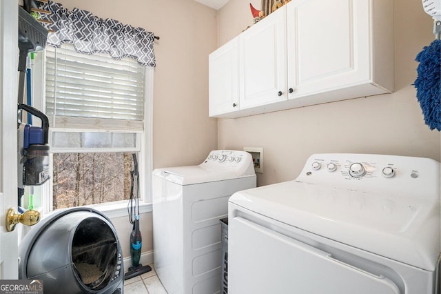 washroom with cabinets, washer and clothes dryer, and light tile patterned floors