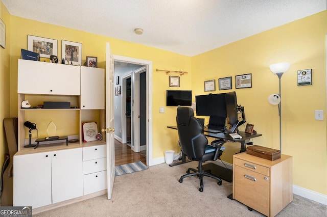 carpeted office with a textured ceiling