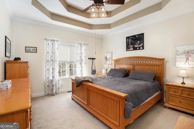 bedroom with a raised ceiling, crown molding, light colored carpet, and ceiling fan