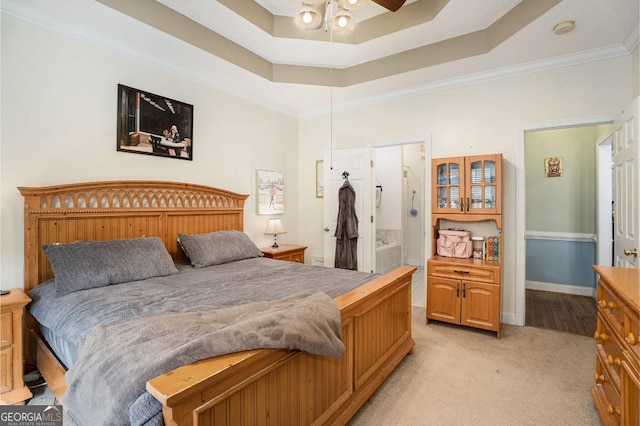 carpeted bedroom with ornamental molding and a raised ceiling