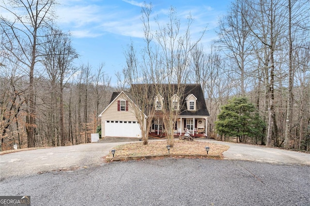 cape cod house with a garage and covered porch