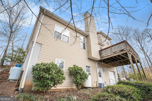 back of property with a garage and a balcony