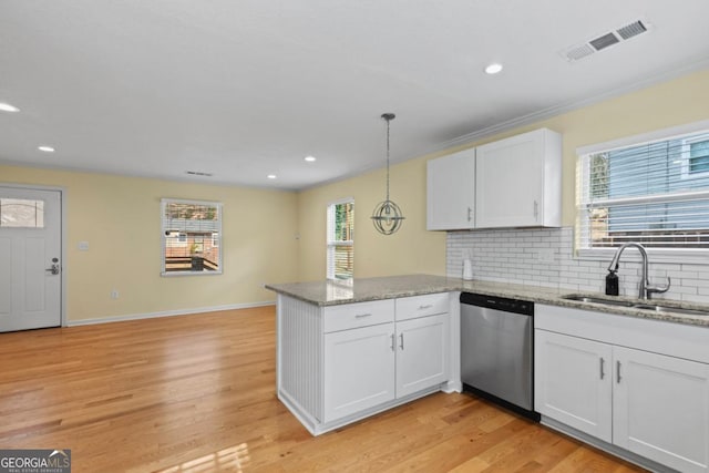 kitchen with decorative light fixtures, white cabinetry, sink, stainless steel dishwasher, and kitchen peninsula