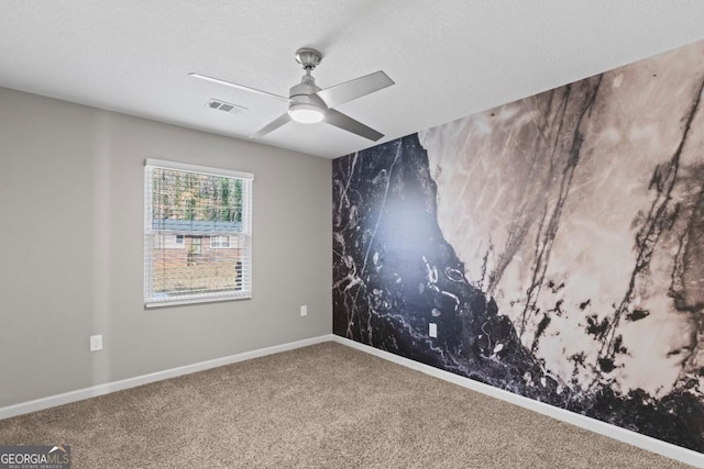 carpeted spare room featuring a textured ceiling and ceiling fan