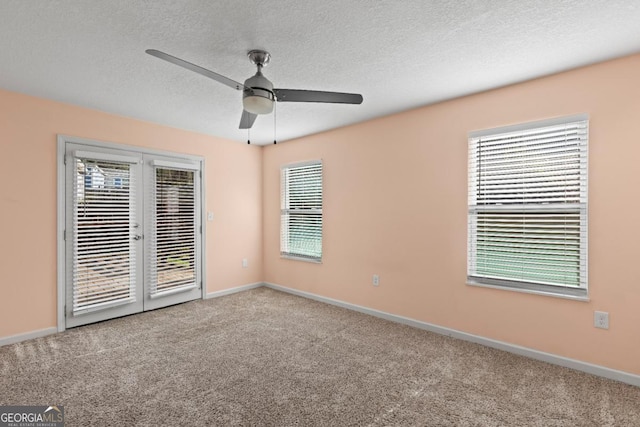 carpeted empty room featuring ceiling fan and a textured ceiling