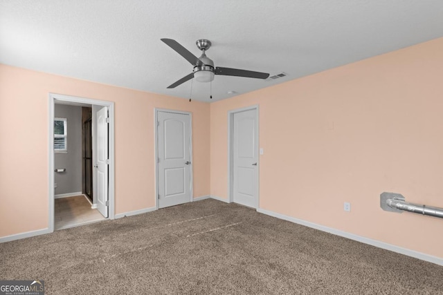 unfurnished bedroom with carpet floors, ceiling fan, and ensuite bathroom