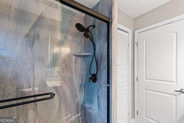 bathroom featuring an enclosed shower and a textured ceiling