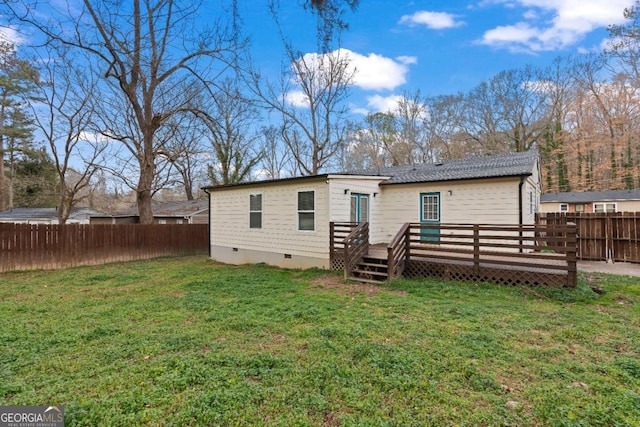 rear view of property featuring a wooden deck and a yard