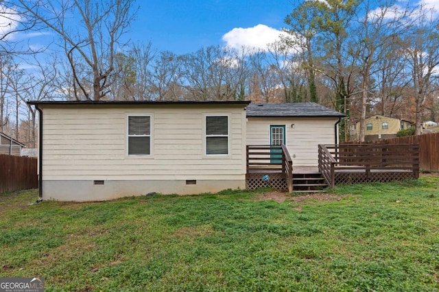 rear view of house with a yard and a deck