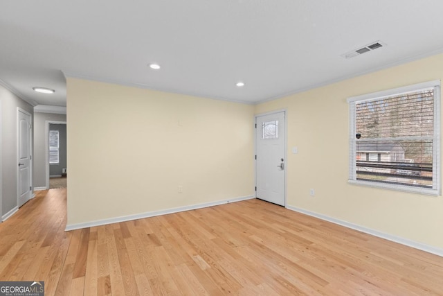 unfurnished room featuring ornamental molding and light hardwood / wood-style floors