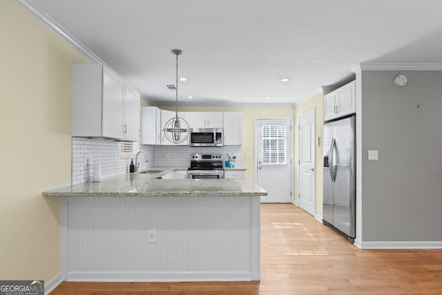 kitchen featuring stainless steel appliances, sink, white cabinets, and kitchen peninsula