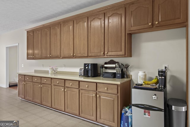 kitchen with brown cabinets, light floors, and light countertops