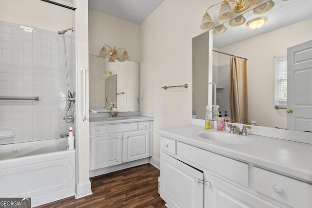 full bathroom featuring shower / bath combination with curtain, two vanities, wood finished floors, and a sink