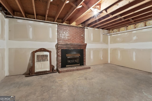 unfinished basement featuring a brick fireplace