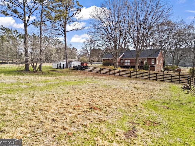 view of yard with an enclosed area, an outdoor structure, and fence