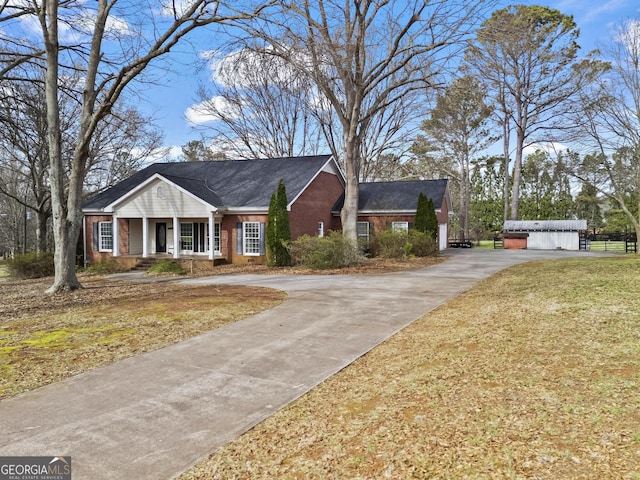 view of front facade featuring brick siding, driveway, and a porch